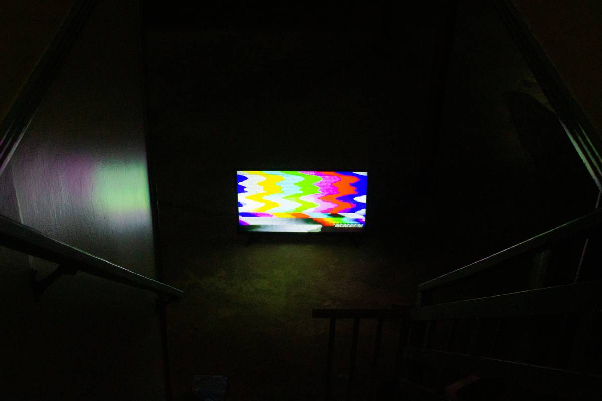 A laptop screen frozen during a video playback with a loading spinner.